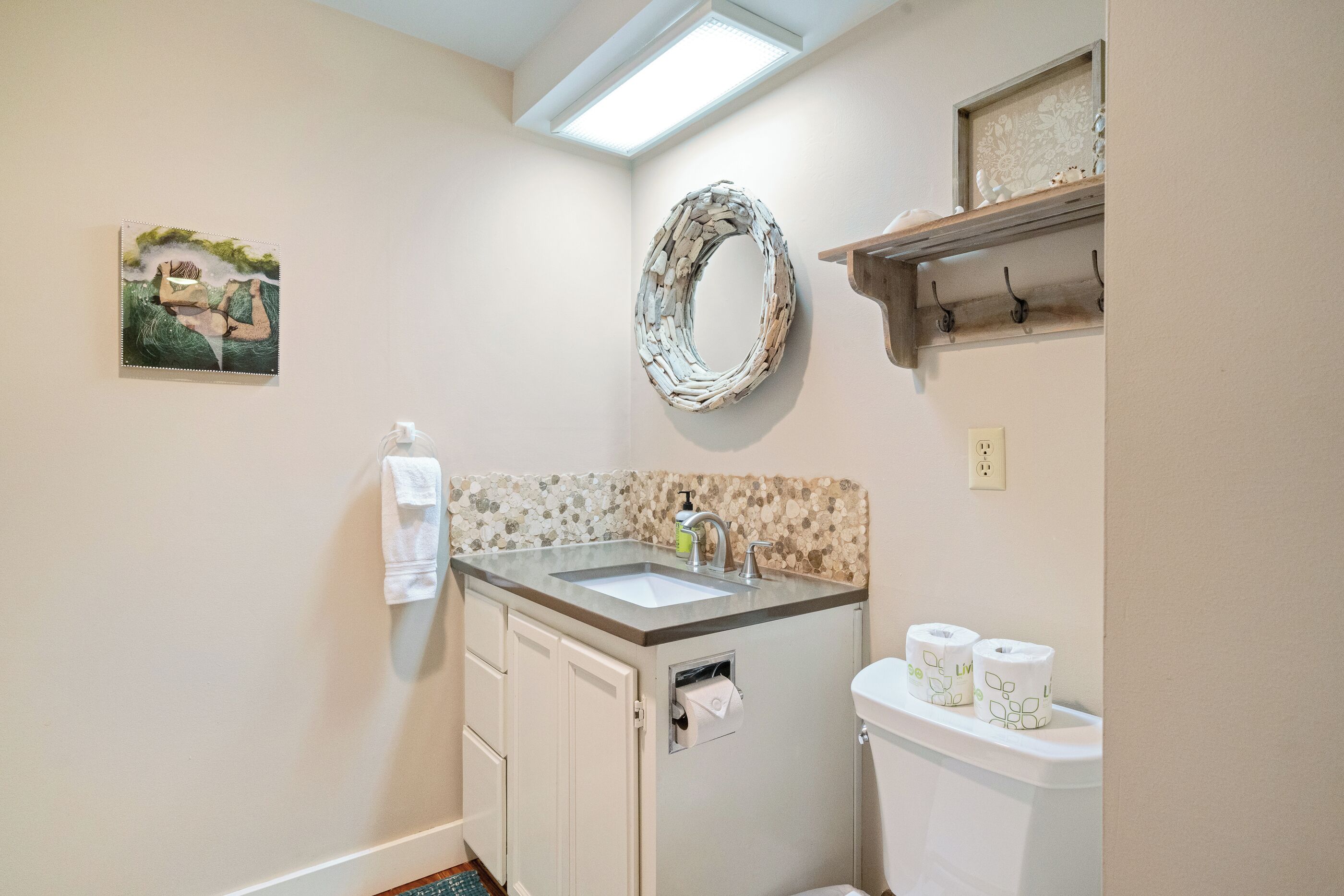 A bathroom with a sink, toilet, and a decorative mirror.