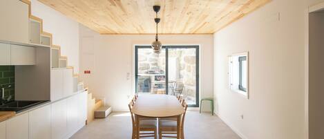 Eine moderne Küche mit Holzschränken und einem Essbereich mit Tisch und Stühlen.
