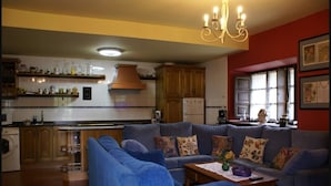 A living room with a blue sofa, a wooden coffee table, and a chandelier. - Green House (Fuentes)