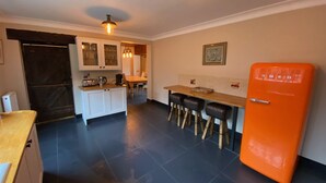 A modern kitchen with a wooden countertop, a built-in oven, and a bar area with stools. - Charming Group Stay – Peaceful Retreat near London (Bexley,)