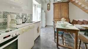 A kitchen with white cabinets, a coffee maker, a toaster, and a clock on the wall.