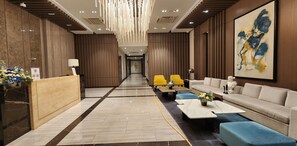 Un moderno vestíbulo de hotel con un mostrador de recepción, zona de estar y un cuadro abstracto grande en la pared.