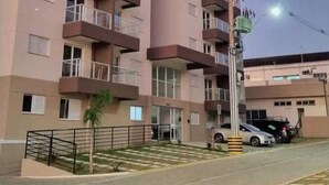 A multi-story residential building with balconies, a gated entrance, and a parking area. - Cozy apartment close to Canção Nova in Condomínio da Fé (Cachoeira Paulista)