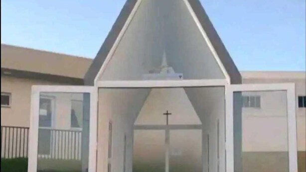 A modern church with a triangular roof and glass doors. Inside, there are pews arranged in rows. - Cozy apartment close to Canção Nova in Condomínio da Fé (Cachoeira Paulista)