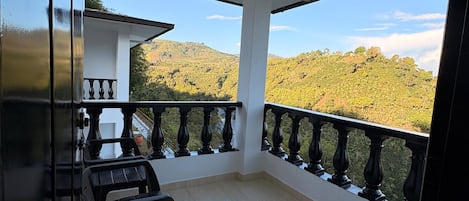 A balcony with a view of a hilly landscape.