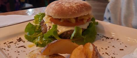 Un plato con una hamburguesa, papas fritas y una ensalada.