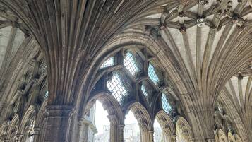 A cathedral interior with high vaulted ceilings and large stained glass windows.