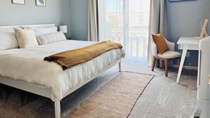 A bedroom with a bed, a desk, and a chair. - Stylish Coastal Retreat in the Heart of the OBX 
2BR•2BA•Pool•Tennis•Patio•WiFi (Kitty Hawk)