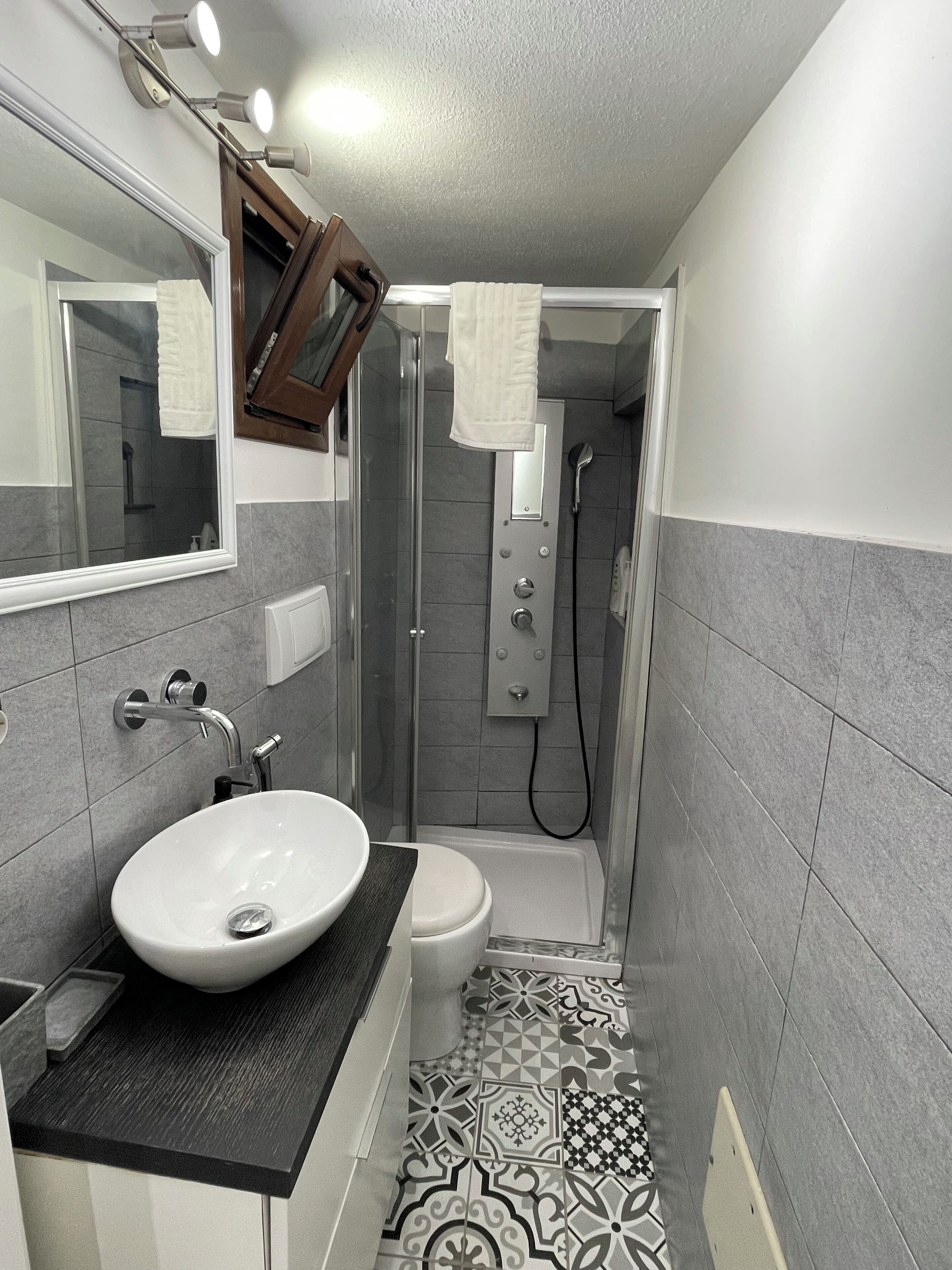 Un baño con lavamanos blanco, inodoro y zona de ducha.