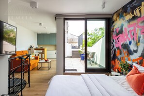 Design studio, 1 queensize bed met slaapbank | Woonruimte | Een flatscreentelevisie