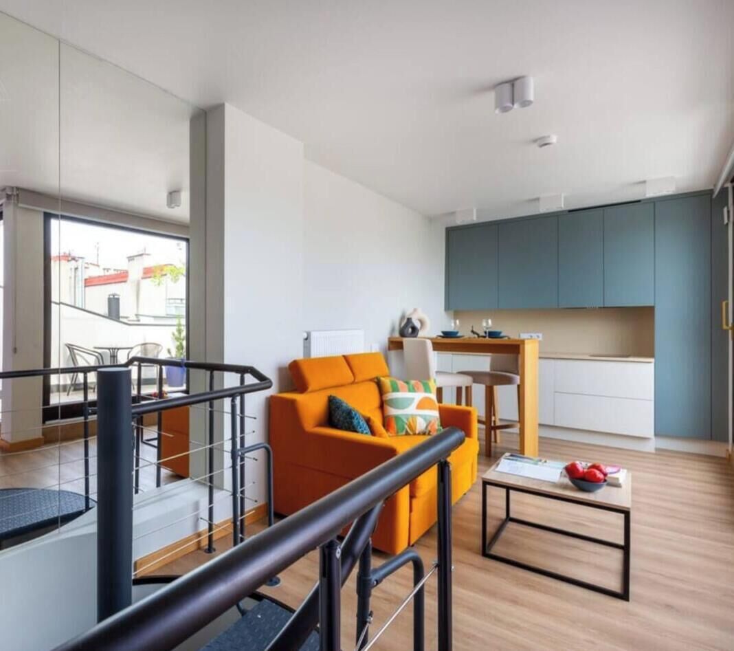A modern apartment with a living area, kitchen, and balcony.