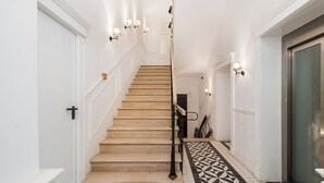 Una escalera con escalones de madera y un suelo con diseño blanco y negro.