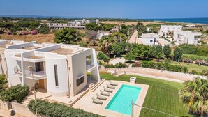 Une villa moderne dotée d’une piscine, d’un espace extérieur couvert et offrant une vue sur la mer.