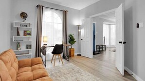 A modern living room with a sofa, a dining table, and a bookshelf. - Luxury & Bright ~ 2 Master BR ~ Games ~ Backyard! (Houston)