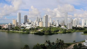 Un paysage urbain avec de hauts immeubles, un grand lac et de la verdure.