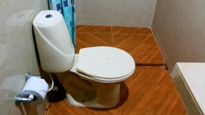 A toilet with a white seat and lid, a toilet paper holder, and a blue and white shower curtain. - Apartment 1c11 Near The Sea With Pool (Cartagena)