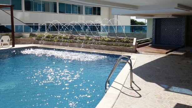 An indoor swimming pool with a clear view of the surrounding building, a water fountain feature, and a tiled floor. - Apartment 1c11 Near The Sea With Pool (Cartagena)