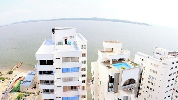 Un hôtel de grande hauteur doté de nombreux balcons offrant une vue sur une plage et la mer.
