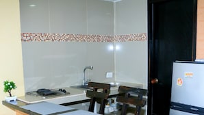 A compact kitchen with a sink, stove, and a refrigerator.