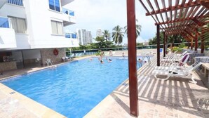 A swimming pool with lounge chairs and a pergola. - Apartment Al-2 Facing the sea With Wifi (Cartagena)
