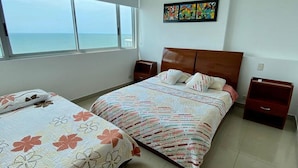 A bedroom with two beds, a large window with a view of the sea, and a colorful painting on the wall. - Apartment Al-1 Facing the sea With Pool and Wifi (Cartagena)