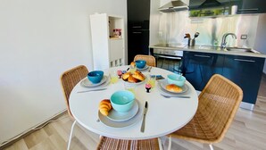 Et moderne køkken med et spisebord dækket til morgenmad, inklusive croissanter og en croissantformet kage.