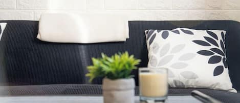 A modern living room with a black and white sofa, a small plant, and a glass of milk on a table.