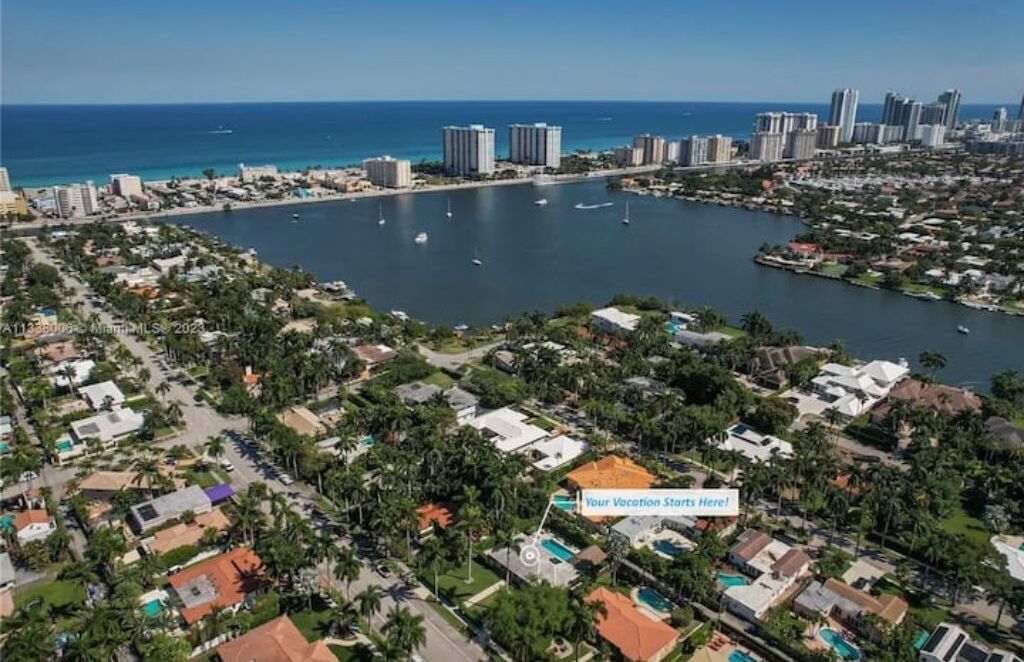 An aerial view of a coastal city with a marina, residential areas, and high-rise buildings.