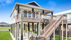 A two-story house with a wooden deck and stairs. - Breezy Ocean View/Sleeps 10/Steps To Beach/Central (Bolivar Peninsula)