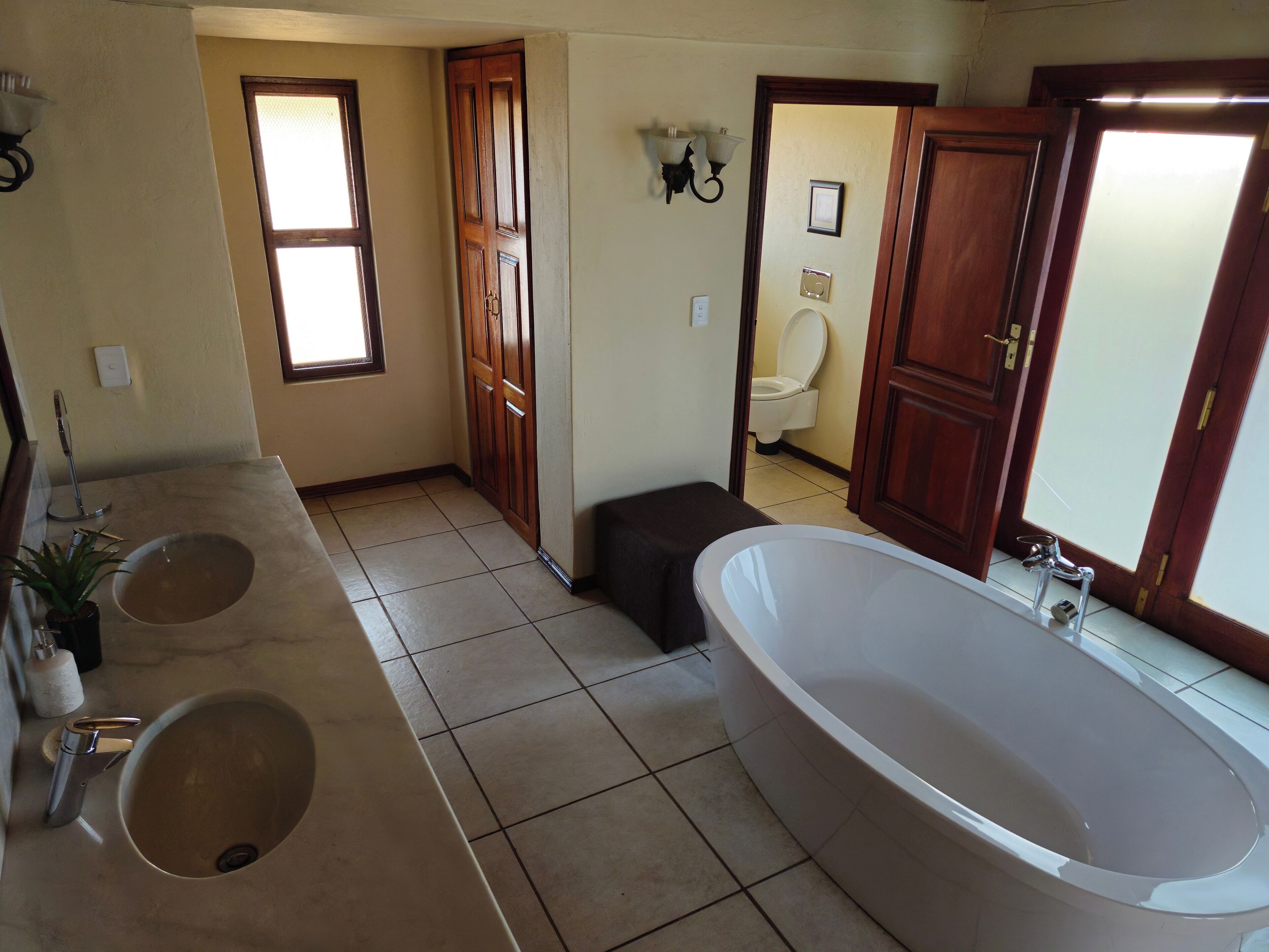 A bathroom with two sinks, a bathtub, and a toilet.