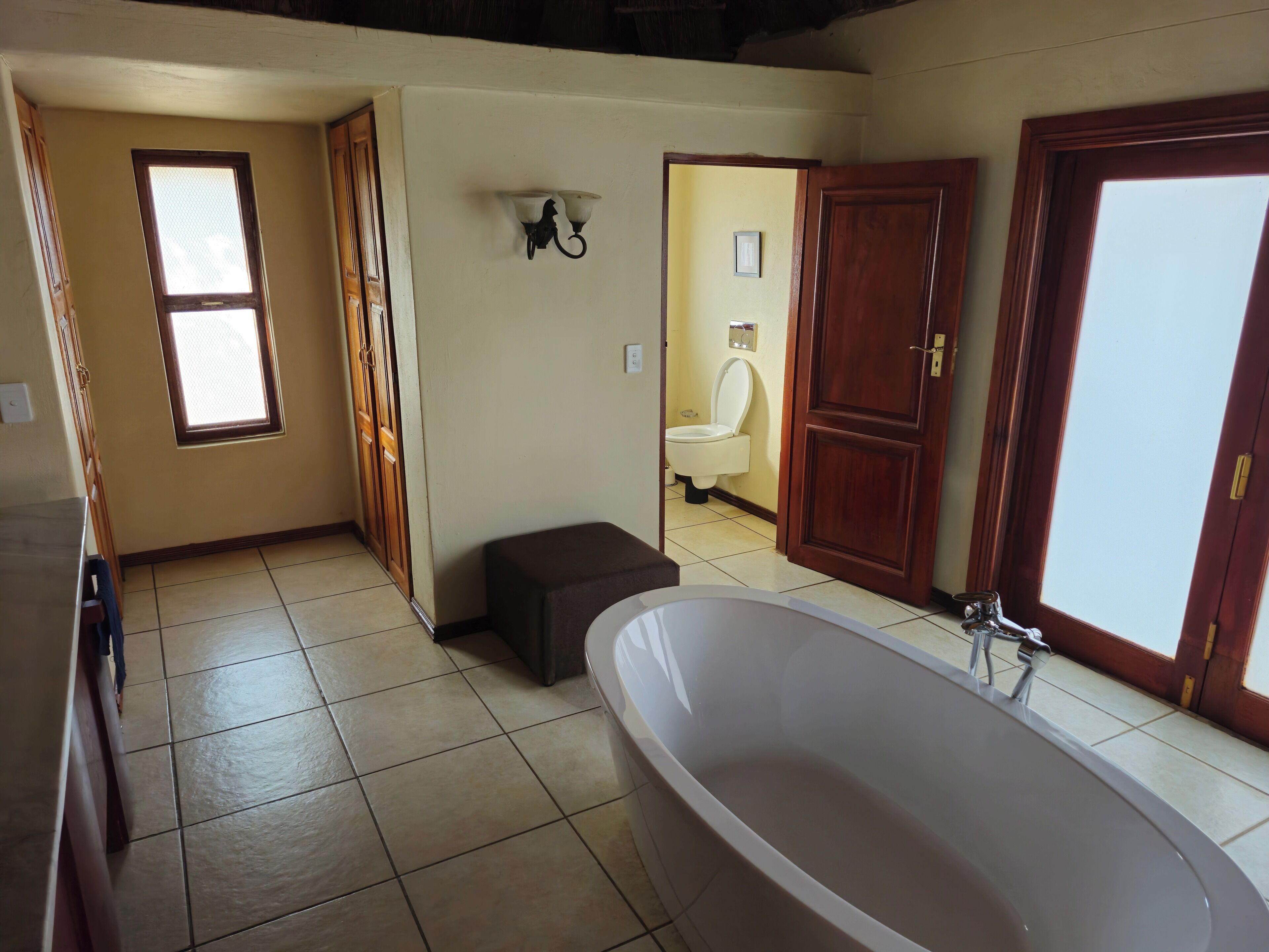 A spacious bathroom with a large bathtub, a toilet, and a shower area.
