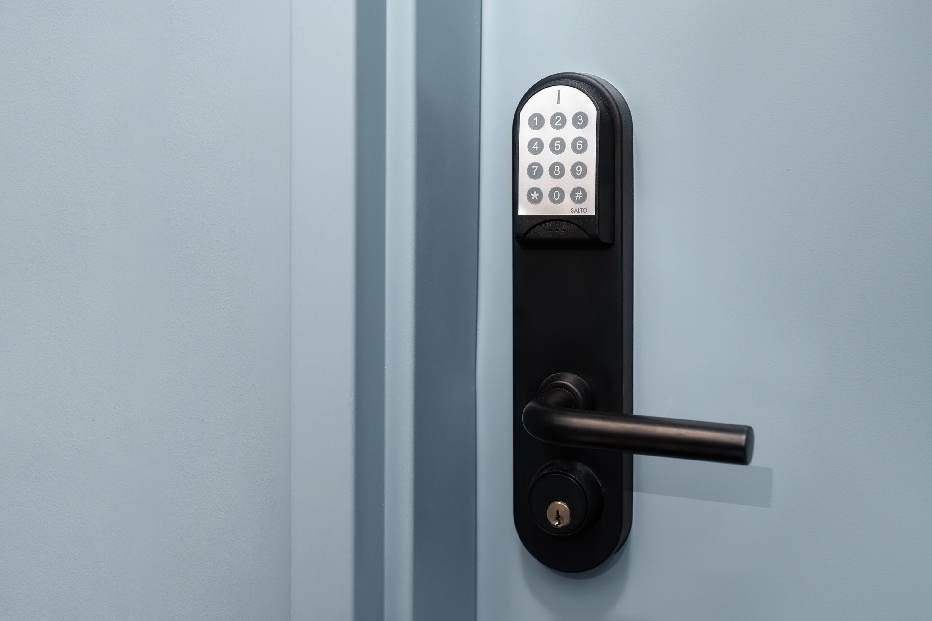 Una porta moderna con serratura a combinazione numerica e chiave.