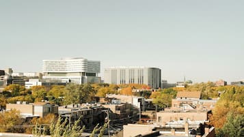 Paisagem urbana com edifícios modernos, incluindo uma estrutura cilíndrica marcante e um edifício retangular com linhas verticais.