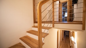 A wooden staircase with metal handrails, leading to an upper floor. - 183A Cristina Hospitality (Ortisei)