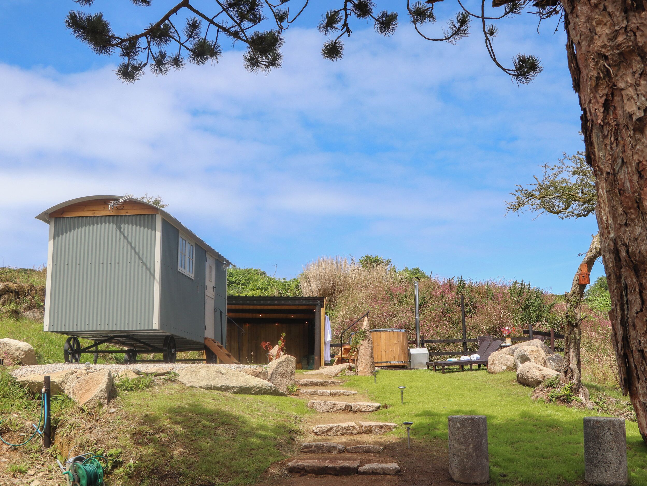 A rustic cabin with a large garage and a covered outdoor area.
