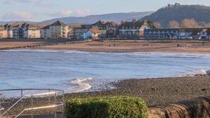 A coastal town with a promenade, buildings, and a hill in the background. - The Outlook (Minehead)