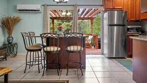 Una cucina con frigorifero integrato, mobili in legno e un'area pranzo con tavolo e sedie.