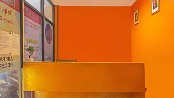 A reception area with a bright orange wall and a reception desk.