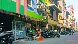 Une rangée de bâtiments aux couleurs vives, dotés de plusieurs unités de climatisation, et une moto garée devant.