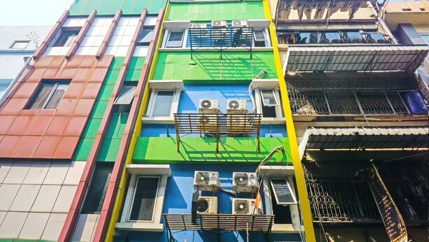Un immeuble à plusieurs étages doté de balcons et de climatiseurs.