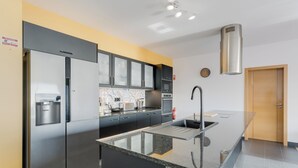 A modern kitchen with stainless steel appliances, a granite countertop, and a built-in oven. - Casa Mozart II (Estreito da Calheta)