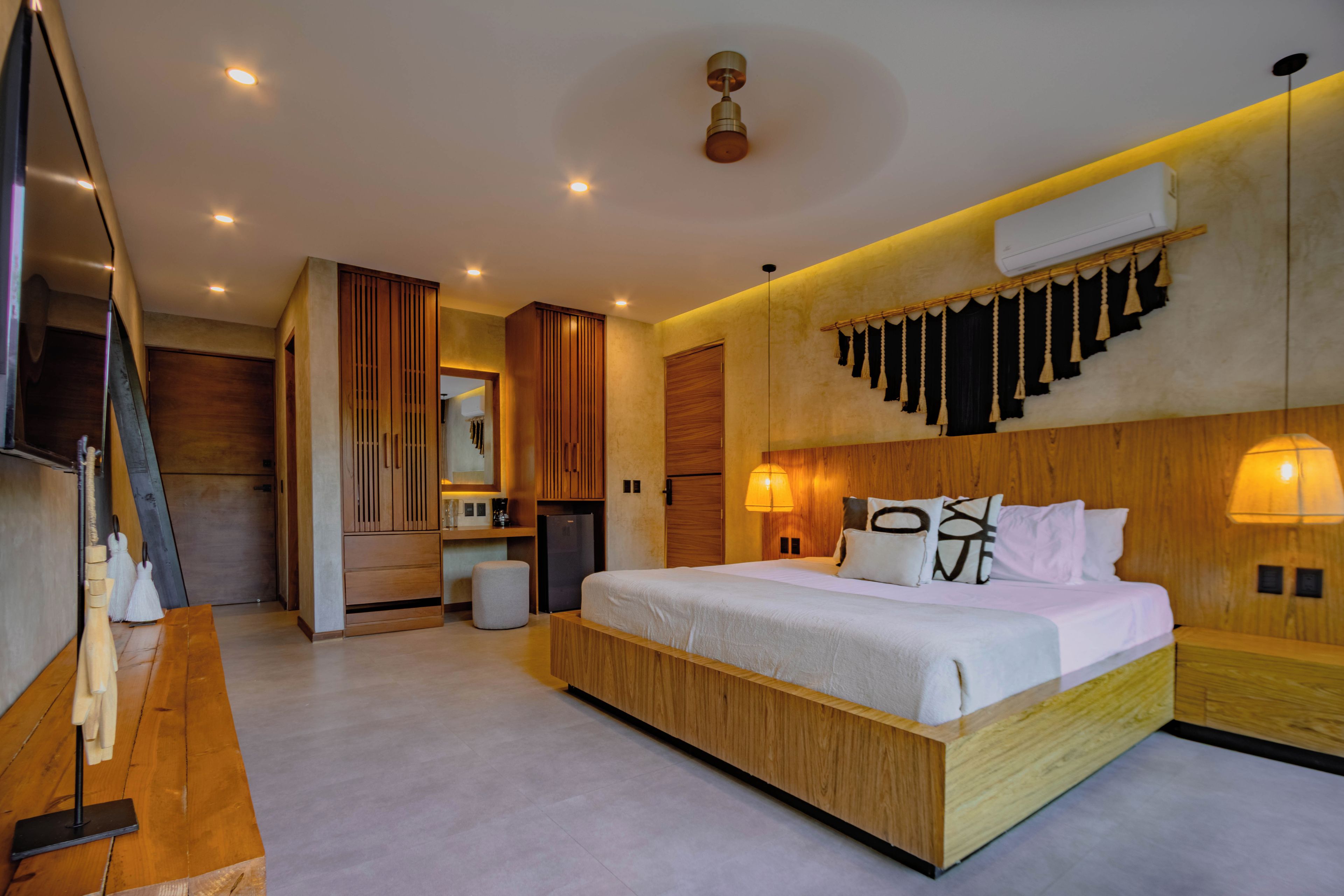 Ein modernes Hotelzimmer mit einem großen Bett, einem Schreibtisch und einem Kleiderschrank.