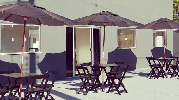 Canoas Hotel with outdoor seating and umbrellas. - Hotel Canoas (Tres Lagoas)