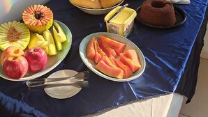 A breakfast buffet with various fruits, pastries, and beverages. - Hotel Canoas (Tres Lagoas)
