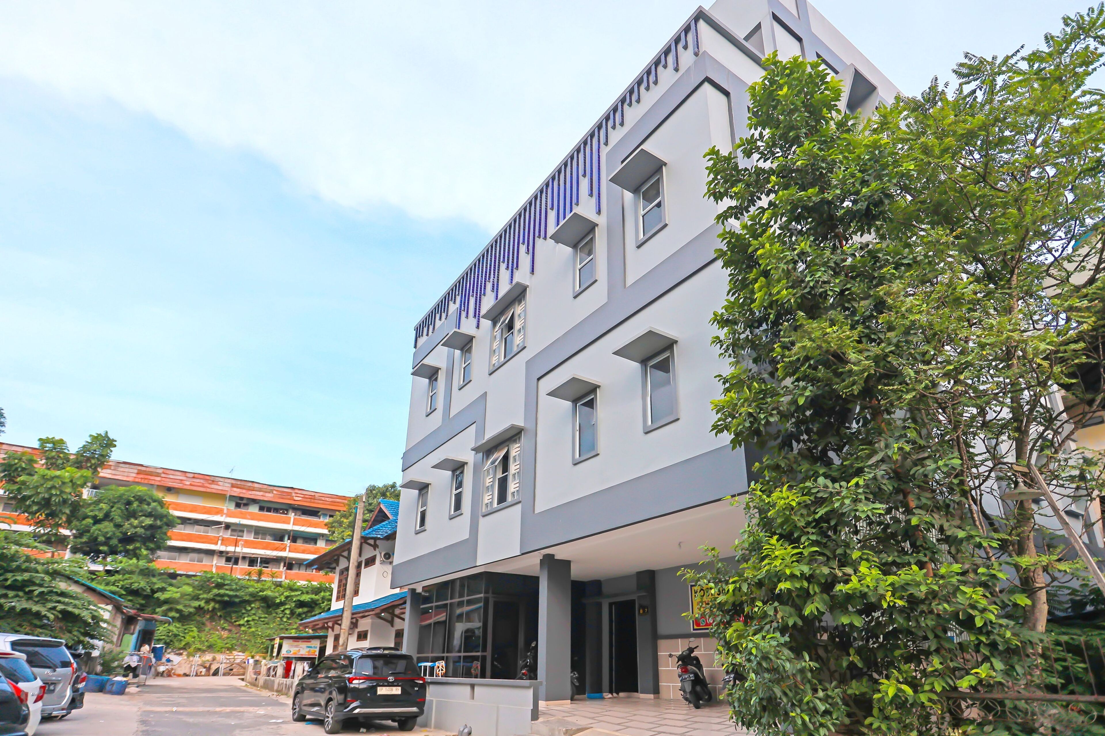 A multi-story building with a modern architectural design, featuring a flat roof and large windows.