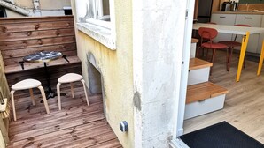 Une cuisine compacte avec des meubles blancs, un évier et un coin repas comprenant une table et des chaises.