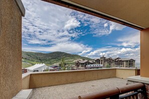 En balkong med utsikt över ett hotellkomplex och den omgivande naturen.