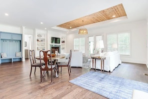 A spacious living area with a dining table, chairs, a sofa, and a coffee table.