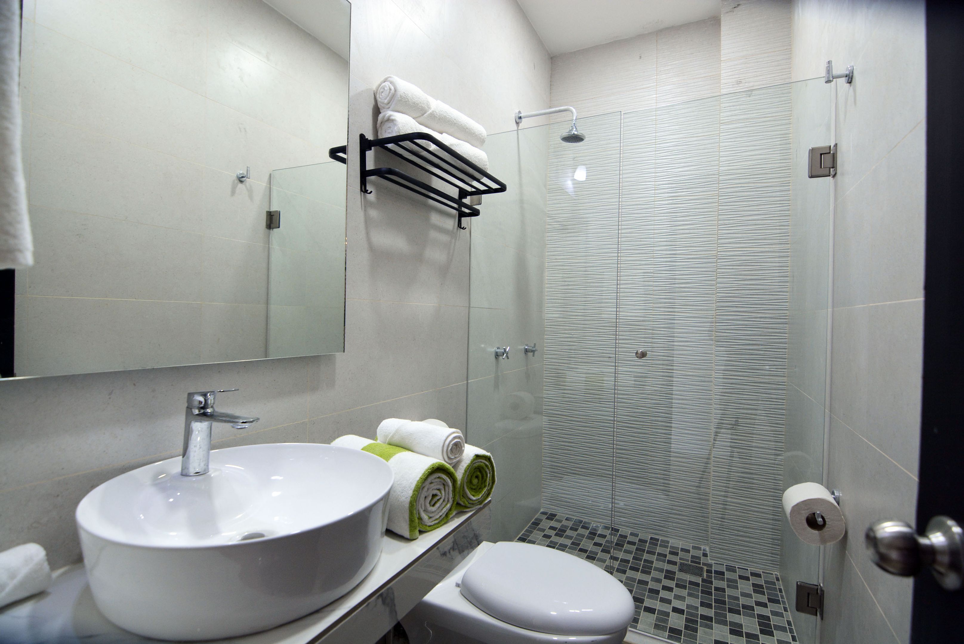 A modern bathroom with a sink, toilet, and glass-enclosed shower.