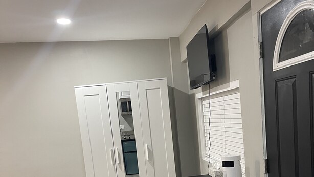 A bedroom with a bed, a desk, a chair, a wardrobe, a TV, and a heater. - A beautiful Studio all inclusive (Allentown)